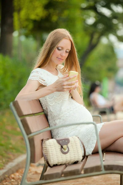 Vrouw op een mobiele beltonen in het park — Stockfoto