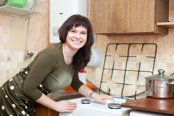 Happy housewife cleans the gas-stove  with melamine sponge — Stock Photo, Image