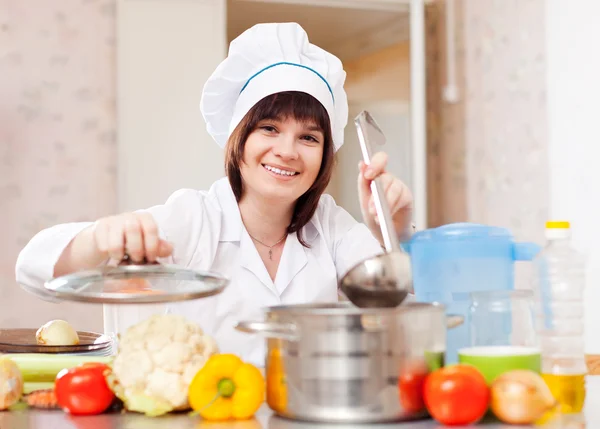 Cocinera cocina con cucharón en la cocina — Foto de Stock