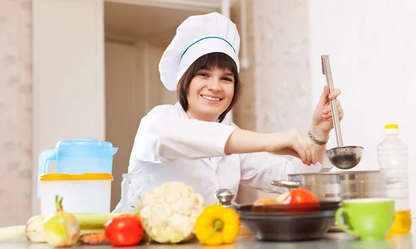 Cook kepçe ile tuz çorba tava içine ekler. — Stok fotoğraf