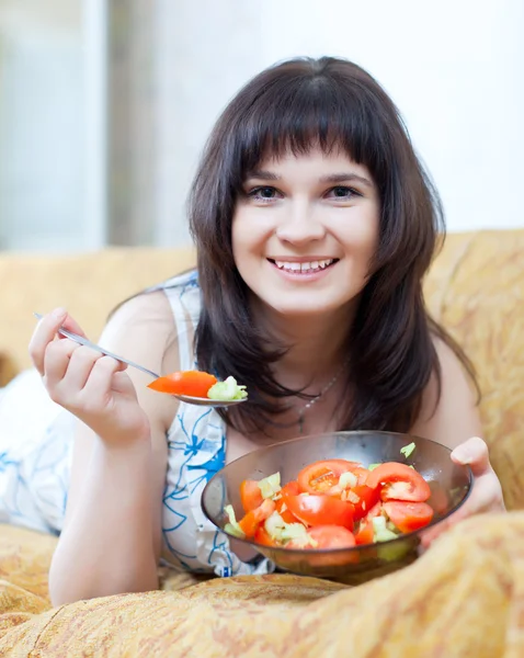 Sorridente donna casuale mangia insalata di pomodori — Foto Stock