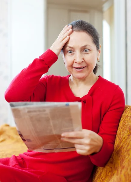 Grief mature woman with newspaper — Stock Photo, Image