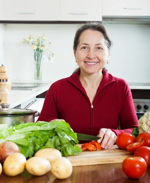 Glad mogen kvinna matlagning lånade kost lunch — Stockfoto