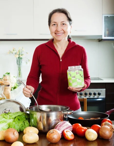Mature woman cooking soup with rice — Stock Photo, Image