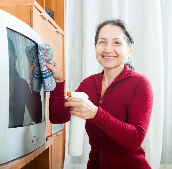 Gewöhnliche reife Frau Staubwischen Fernseher — Stockfoto