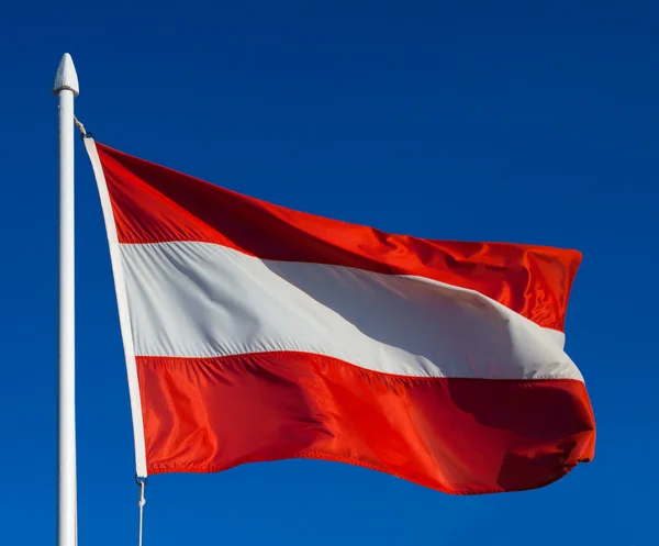 Flagge Österreichs vor blauem Himmel — Stockfoto