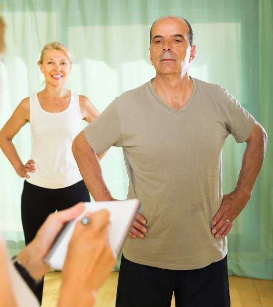 Pareja madura con entrenador en el gimnasio —  Fotos de Stock