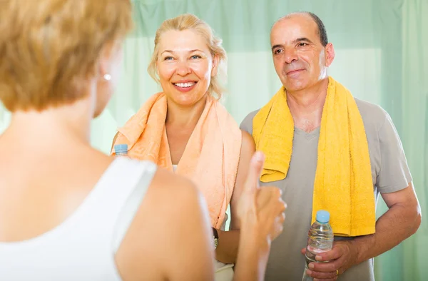 Elderly couple talking to trainer — Stock Photo, Image