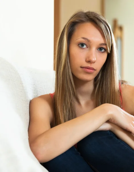 Smutna dziewczyna siedzi na kanapie — Zdjęcie stockowe