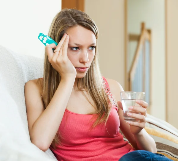 Vrouw met glas water en pillen — Stockfoto