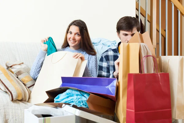 Happy friends with clothes and shopping bags — Stock Photo, Image