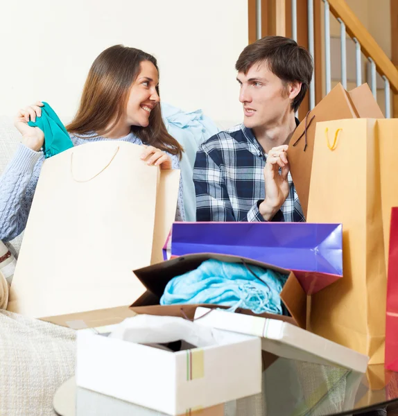 Famille heureuse avec vêtements et sacs à provisions — Photo