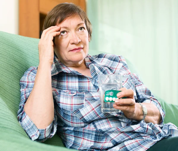 Rentner mit Tabletten und Glas Wasser — Stockfoto