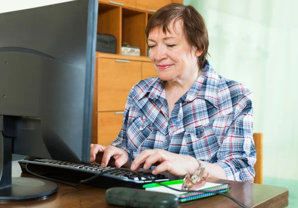 Elderly woman working with computer — Stock Photo, Image