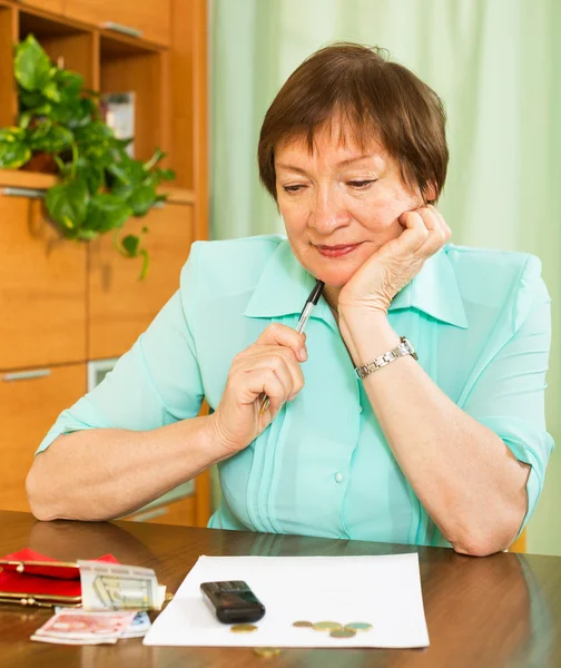 Mujer pensativa sentada a la mesa — Foto de Stock