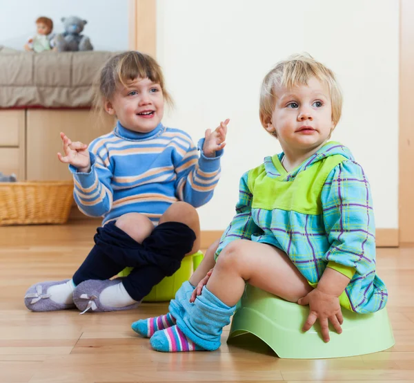 Twee broers en zussen op kamer potten — Stockfoto