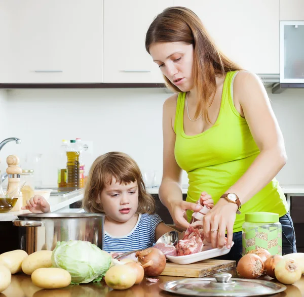 Mulher com bebê cozinhar — Fotografia de Stock