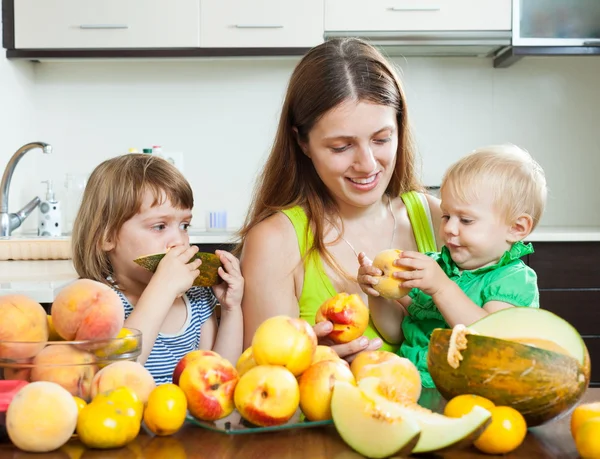 Woman and daughters with peaches — Stock Photo, Image