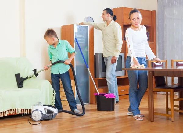 Familie reinigen met een stofzuiger — Stockfoto