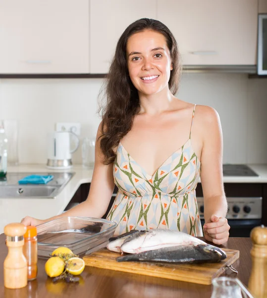 Женщина готовит рыбу на кухне — стоковое фото