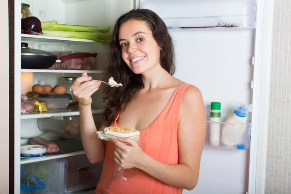 Vrouw die taart eet uit koelkast — Stockfoto