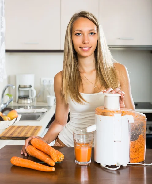 Meisje maken wortelsap — Stockfoto