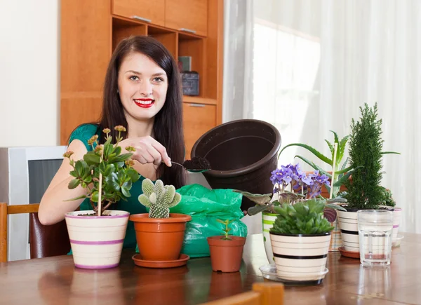 Donna sorridente trapianto di fiori pianta — Foto Stock