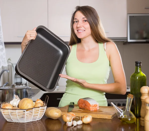 Smiling housewife cooking   salmon — Stock Photo, Image