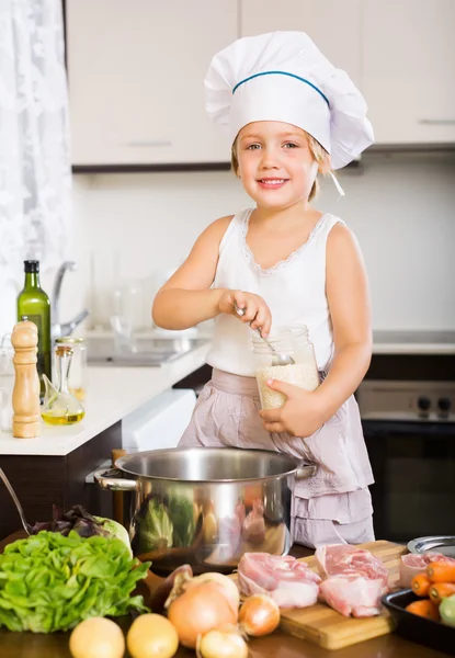 Bebê feliz menina no chapéu cozinheiro cozinhar sopa — Fotografia de Stock