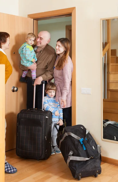 Man en vrouw met twee kinderen komt thuis — Stockfoto