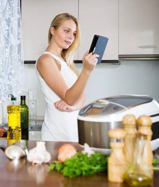 Hemmafru matlagning med läsplatta — Stockfoto