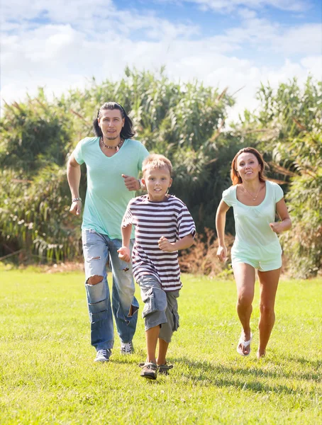 Famiglia di tre persone che corrono al parco — Foto Stock