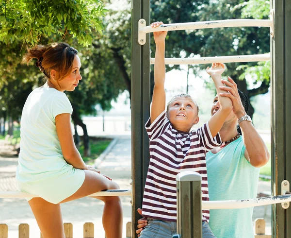 Pareja con hijo entrenando con barra de mentón —  Fotos de Stock