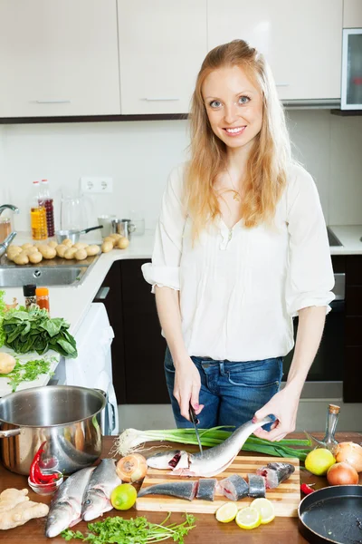 Ama de casa positiva cocinar pescado de agua salada —  Fotos de Stock