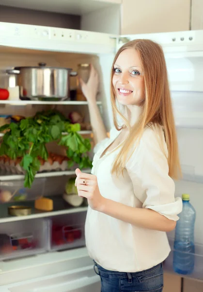冷蔵庫に何かを探している女性 — ストック写真