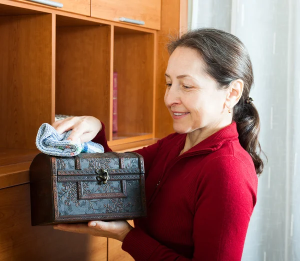 Mujer limpiando polvo del pecho de madera —  Fotos de Stock