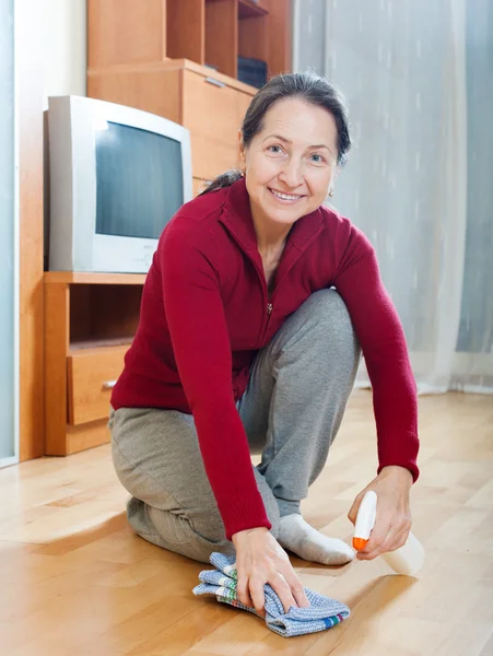 Frau reibt Boden mit Politur — Stockfoto