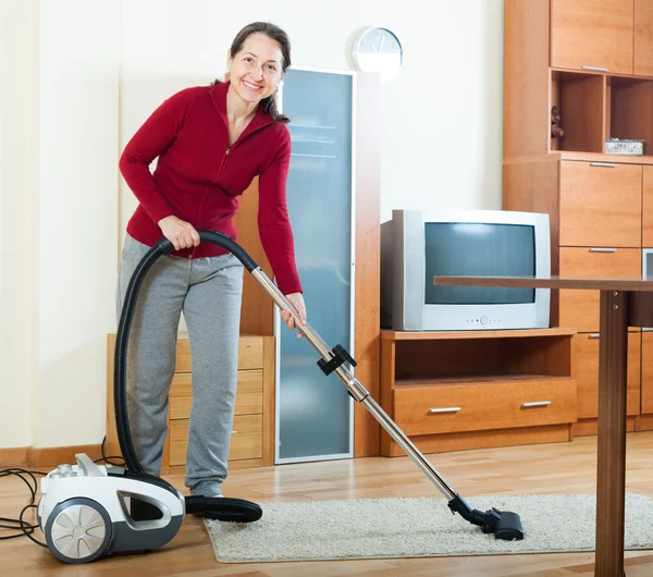 Frau putzt mit Staubsauger — Stockfoto