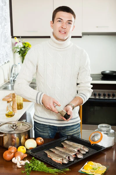 Handsome man adding  seasonings in  fish — Stock Photo, Image