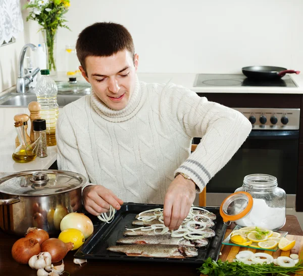 Hombre cocinando pescado crudo y cebolla —  Fotos de Stock