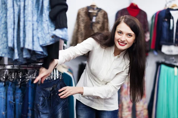 Jovem mulher escolhendo jeans — Fotografia de Stock