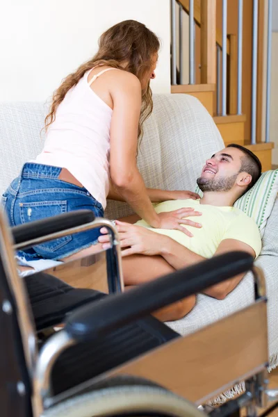 Par på soffa nära rullstol — Stockfoto