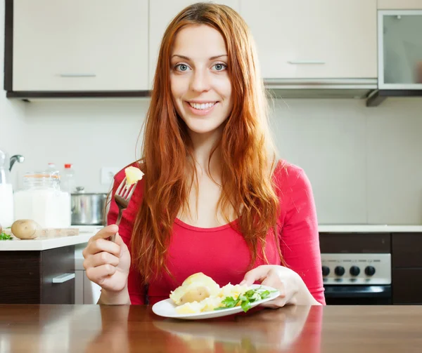 Femme mangeant des pommes de terre — Photo