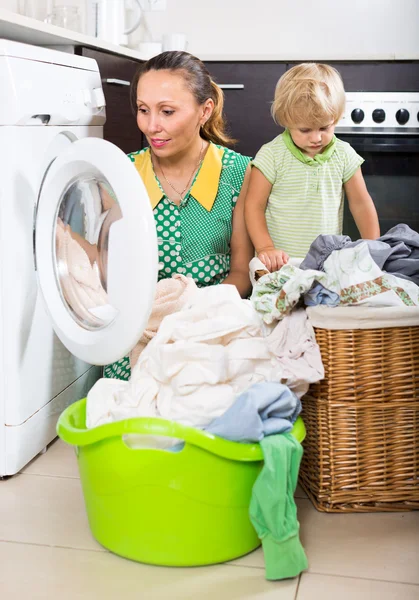 Mulher com criança perto da máquina de lavar roupa — Fotografia de Stock