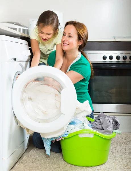 Женщина с дочерью стирает одежду — стоковое фото