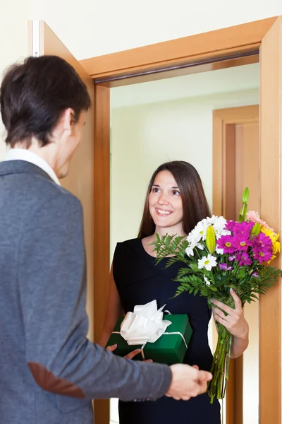 Woman giving flowers and gift — Stock Photo, Image