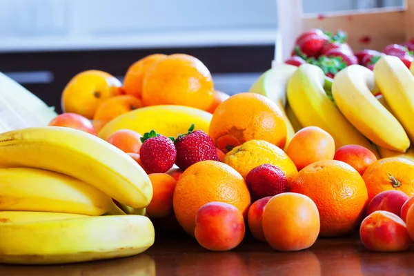 Fresh fruits on kitchen table — Stock Photo, Image