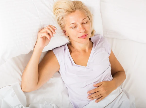 Middelbare leeftijd vrouw slapen in bed — Stockfoto