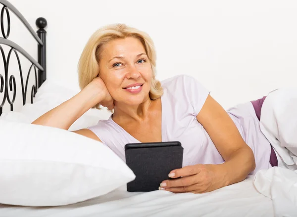 Mature woman resting with ereader — Stock Photo, Image