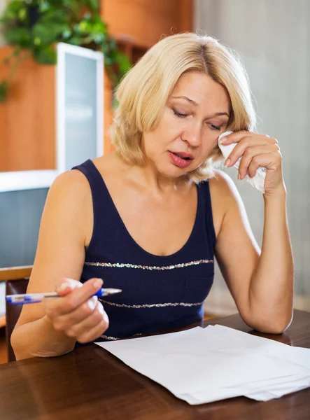 Sad woman sits at table — Stock Photo, Image